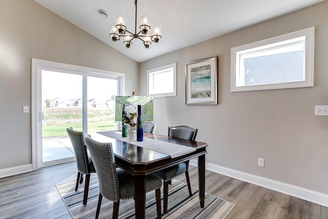 10017 177th Ave NW, Elk River, MN 55330 - dining room featuring light wood finished floors, a notable chandelier, baseboards, and vaulted ceiling