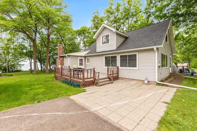 42271 Vista Road, East Side Twp, MN 56342 - back of house with a patio, roof with shingles, a deck, a lawn, and a chimney