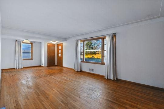 7335 Penn Ave S, Richfield, MN 55423 - unfurnished living room featuring wood finished floors and baseboards