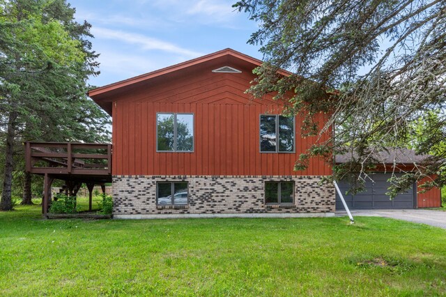 409 Dale Dr SE, Remer, MN 56672 - view of side of home featuring concrete driveway, a lawn, a wooden deck, and a garage