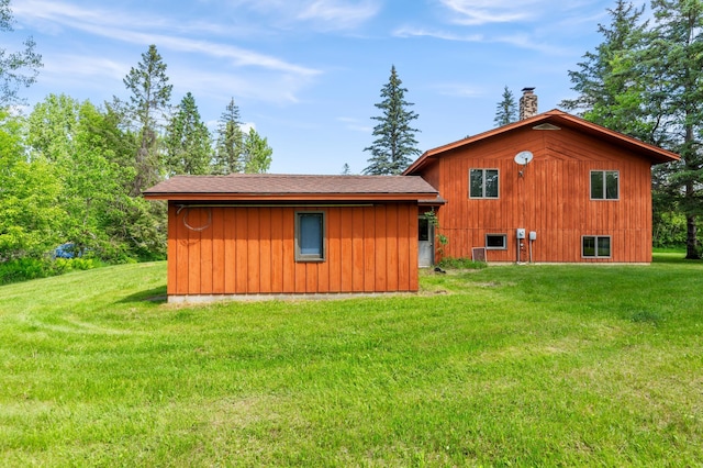 409 Dale Dr SE, Remer, MN 56672 - view of home's exterior with a chimney, a lawn, and a shingled roof