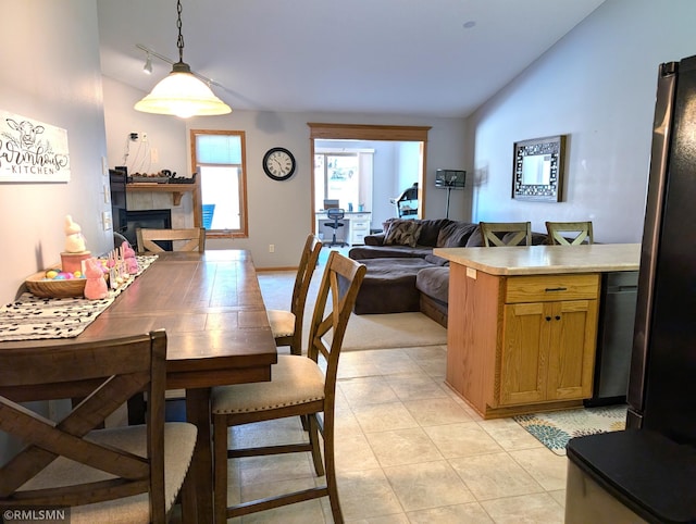 902 Meadow Lark Ln, Long Prairie, MN 56347 - dining space with lofted ceiling, a tiled fireplace, and light tile patterned flooring