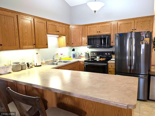 902 Meadow Lark Ln, Long Prairie, MN 56347 - kitchen featuring freestanding refrigerator, black electric range oven, a sink, a peninsula, and brown cabinetry