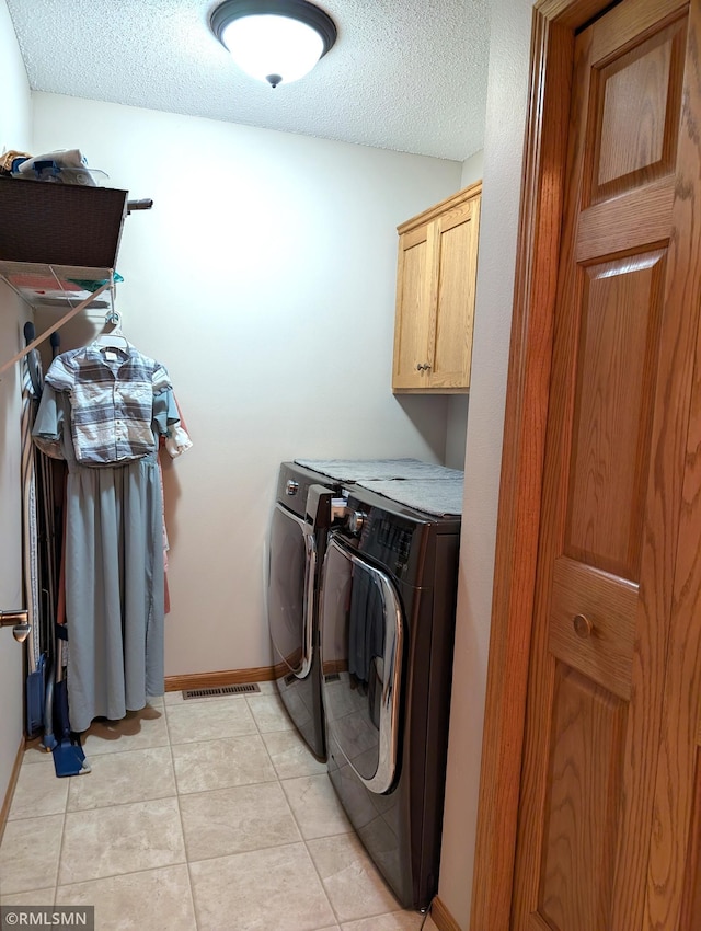 902 Meadow Lark Ln, Long Prairie, MN 56347 - laundry area featuring cabinet space, washer and clothes dryer, a textured ceiling, light tile patterned floors, and baseboards