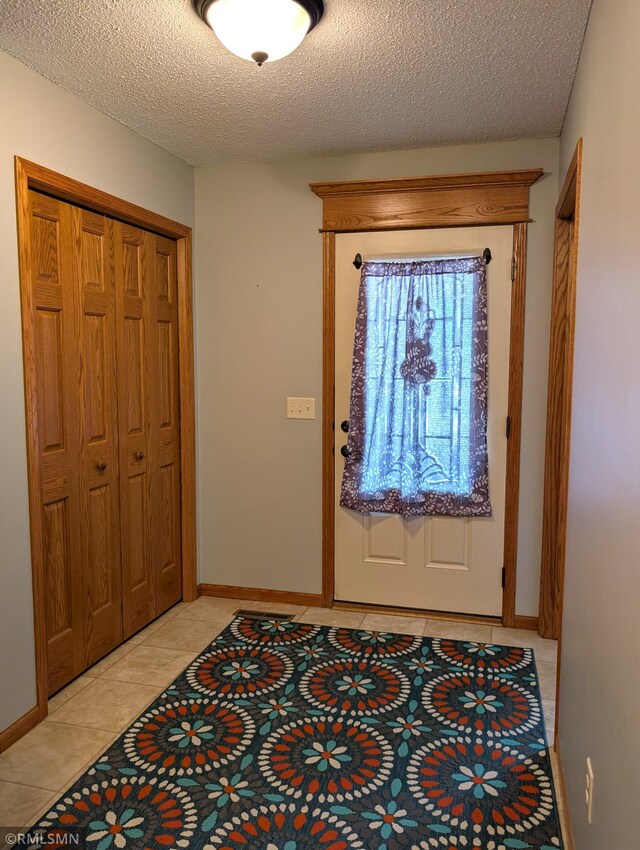 902 Meadow Lark Ln, Long Prairie, MN 56347 - entrance foyer with light tile patterned floors, baseboards, and a textured ceiling