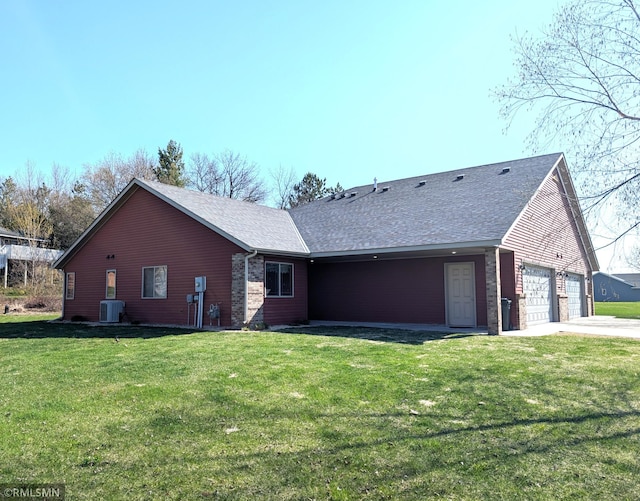 902 Meadow Lark Ln, Long Prairie, MN 56347 - back of property featuring central AC unit, a yard, driveway, an attached garage, and a shingled roof