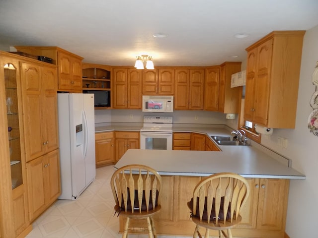 kitchen featuring white appliances, a peninsula, open shelves, light countertops, and a sink