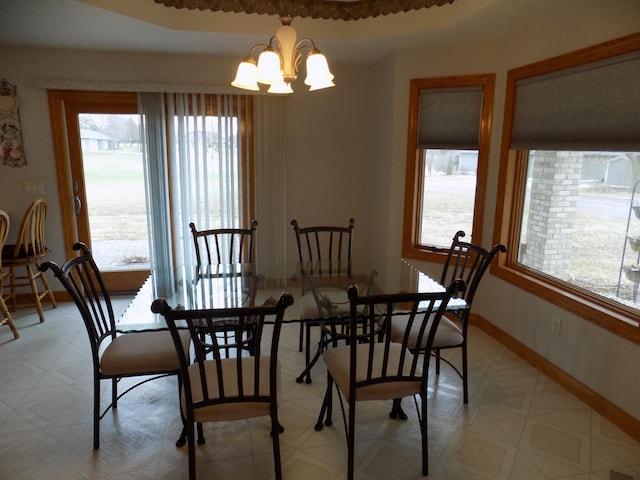 dining room featuring a notable chandelier, baseboards, and light floors