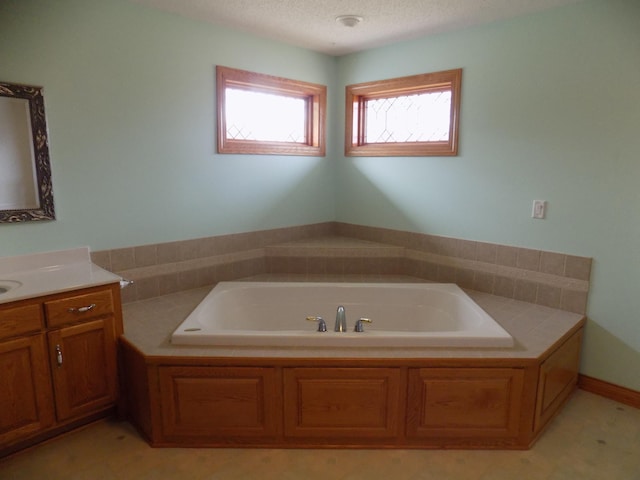 bathroom featuring a bath, vanity, and a textured ceiling