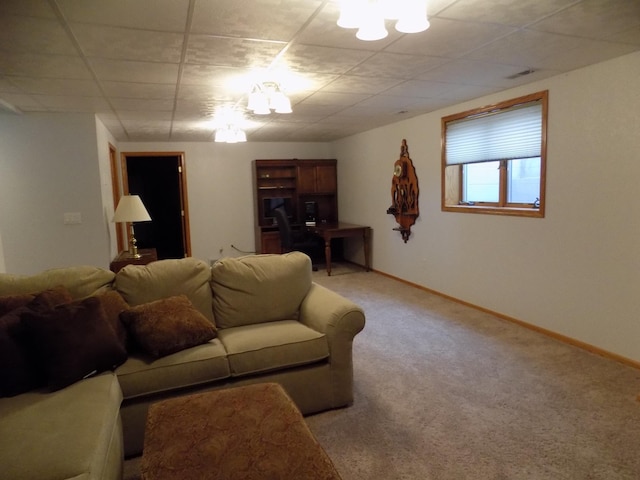 living area featuring baseboards, a paneled ceiling, and light colored carpet