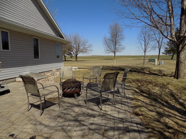 view of patio / terrace featuring an outdoor fire pit and a rural view