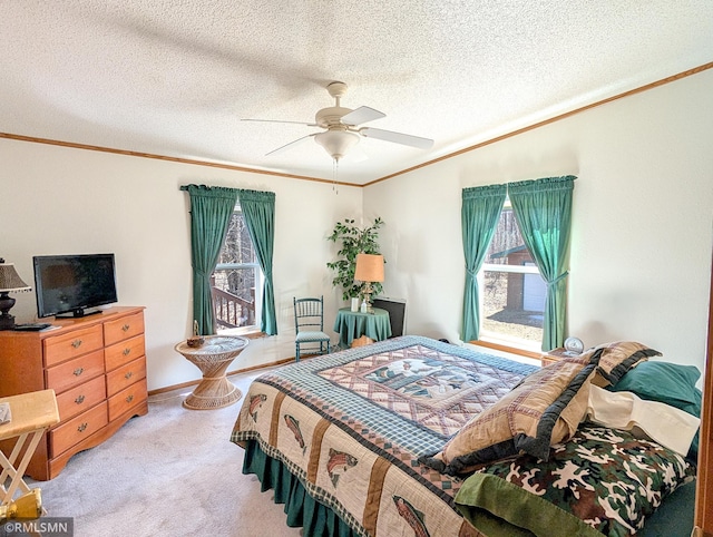 bedroom with baseboards, ceiling fan, a textured ceiling, crown molding, and carpet floors