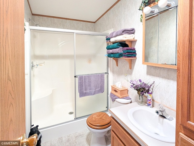 bathroom with ornamental molding, toilet, a stall shower, and vanity