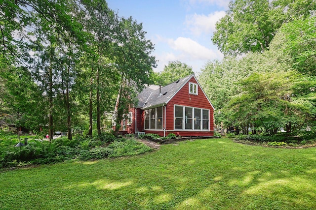19135 Highland Ave, Deephaven, MN 55391 - rear view of house featuring a sunroom, a lawn, and roof with shingles