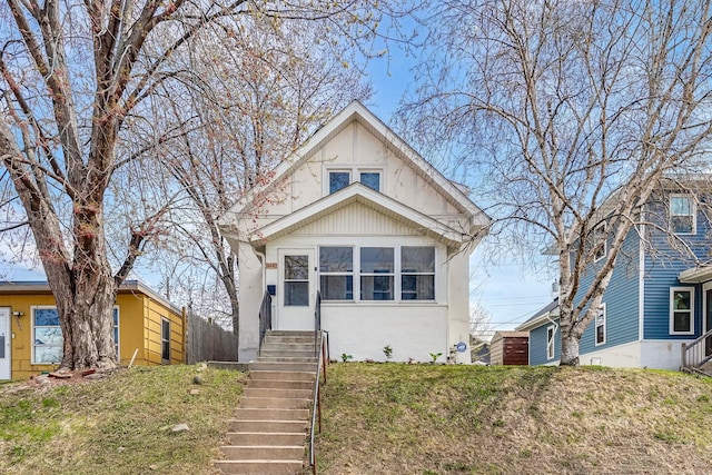 view of front of home featuring fence, a front yard, and stucco siding