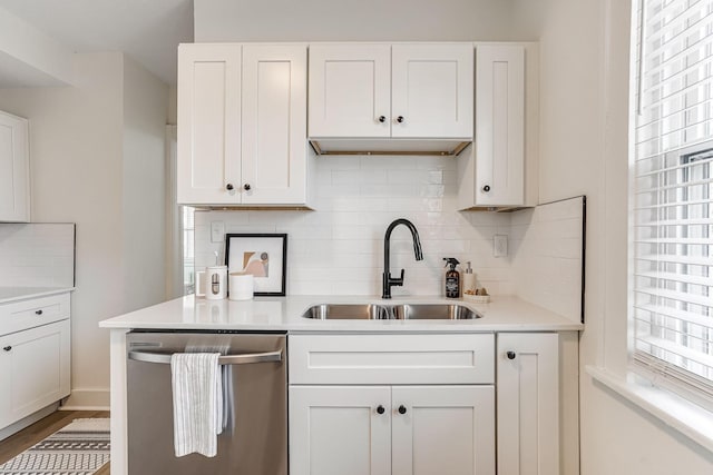 kitchen featuring a sink, light countertops, decorative backsplash, and dishwasher