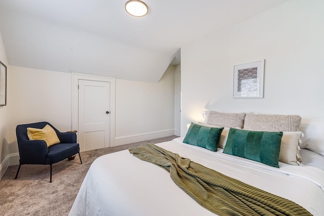 bedroom with baseboards, carpet, and lofted ceiling