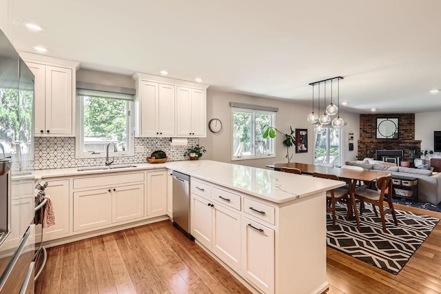 7488 Hydram Ave S, Cottage Grove, MN 55016 - kitchen with a sink, dishwasher, a peninsula, light wood finished floors, and plenty of natural light