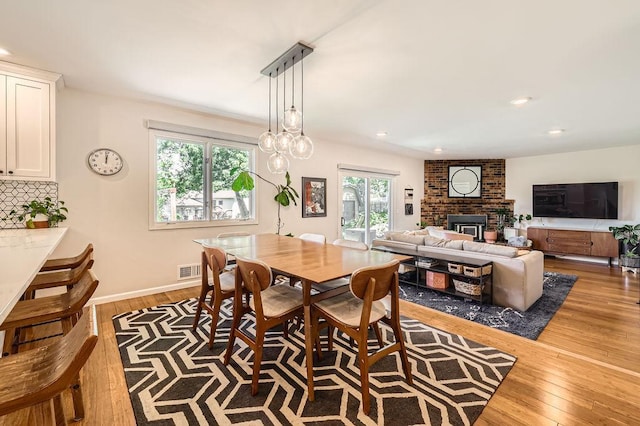 7488 Hydram Ave S, Cottage Grove, MN 55016 - dining space featuring a fireplace, wood finished floors, and recessed lighting