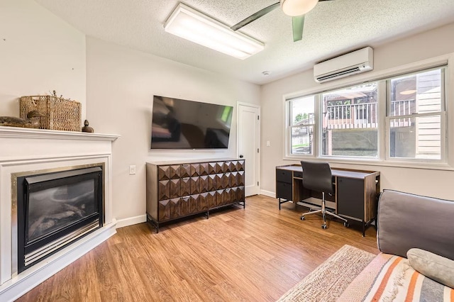 7488 Hydram Ave S, Cottage Grove, MN 55016 - home office featuring a wall mounted air conditioner, wood finished floors, a textured ceiling, ceiling fan, and baseboards