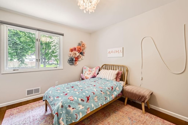 7488 Hydram Ave S, Cottage Grove, MN 55016 - bedroom with baseboards, wood finished floors, and a chandelier