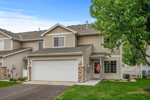 1324 Pembrooke Ln, Waconia, MN 55387 - view of front of house with asphalt driveway, a garage, a shingled roof, and stone siding