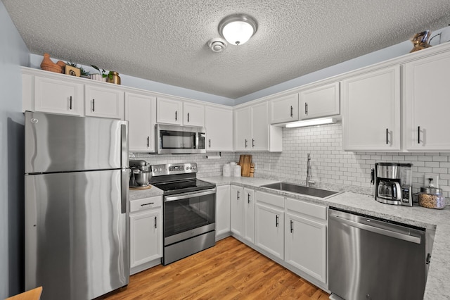 1324 Pembrooke Ln, Waconia, MN 55387 - kitchen with appliances with stainless steel finishes, white cabinetry, a textured ceiling, and light wood-type flooring
