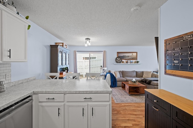 1324 Pembrooke Ln, Waconia, MN 55387 - kitchen with dishwasher, a textured ceiling, a peninsula, light countertops, and white cabinets