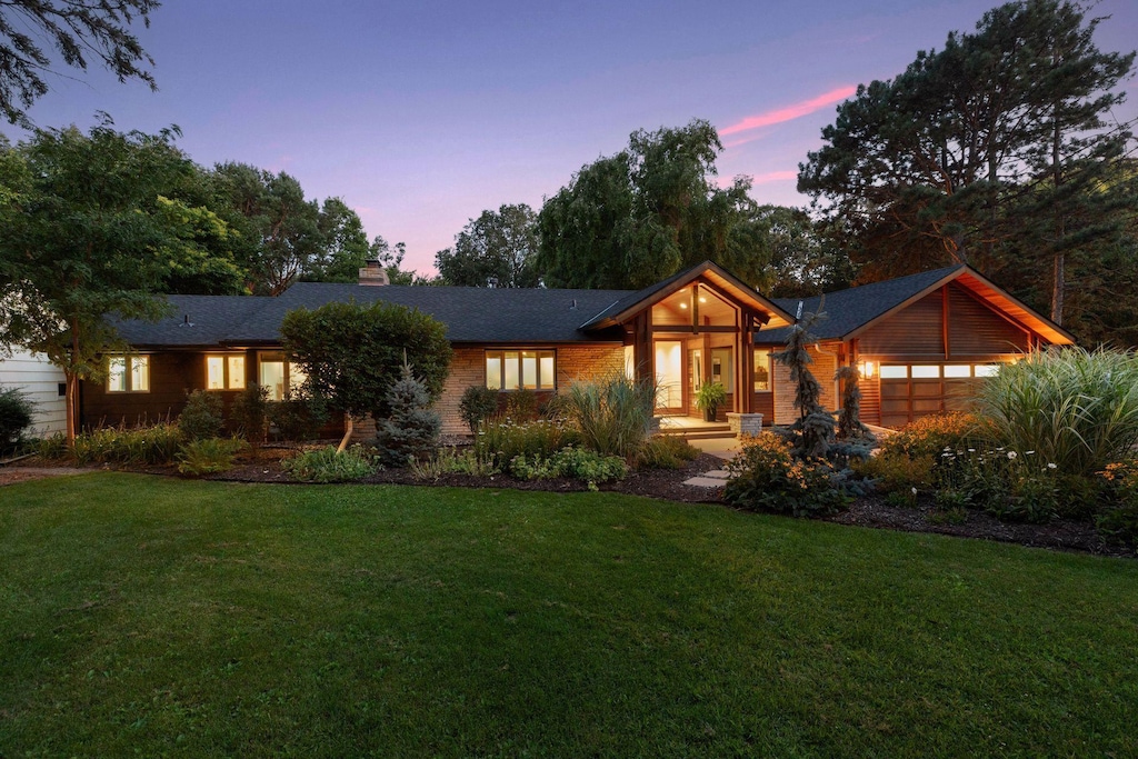 view of front of home featuring a yard, a garage, and a chimney