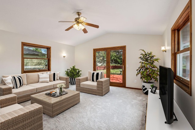 living room featuring a ceiling fan, vaulted ceiling, plenty of natural light, and light carpet