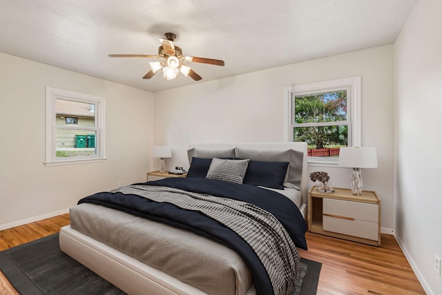 bedroom with baseboards, a ceiling fan, and wood finished floors