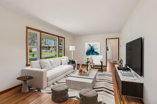 living area featuring baseboards and wood finished floors