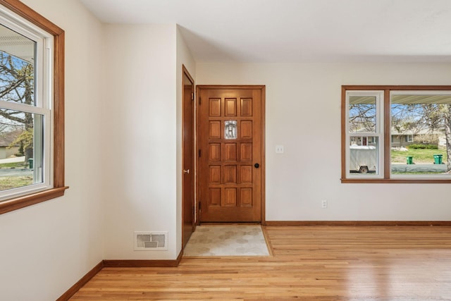 entrance foyer featuring baseboards, plenty of natural light, light wood-type flooring, and visible vents