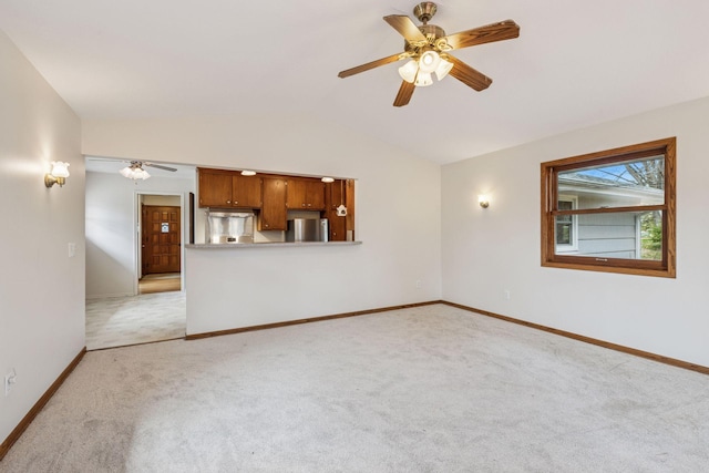 unfurnished living room with light colored carpet, baseboards, ceiling fan, and vaulted ceiling