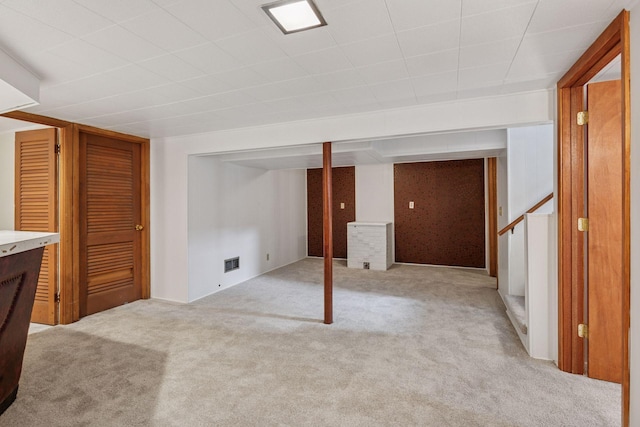 finished basement with visible vents and light carpet
