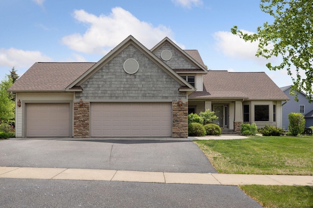 2164 Rushmore Dr, River Falls, WI 54022 - view of front facade featuring an attached garage, driveway, a front lawn, roof with shingles, and stone siding