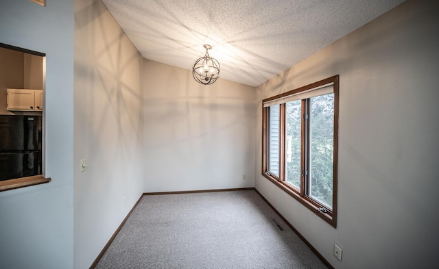 unfurnished dining area featuring a textured ceiling, visible vents, baseboards, carpet, and a notable chandelier