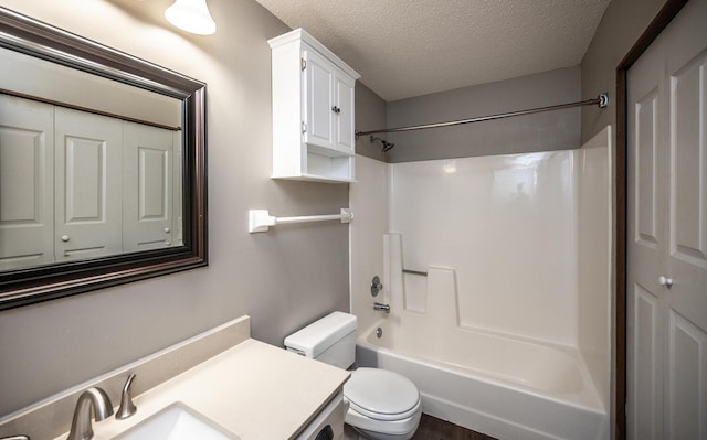 full bathroom featuring toilet, a textured ceiling, shower / bathtub combination, and vanity