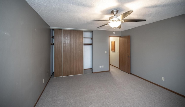 unfurnished bedroom with carpet flooring, baseboards, a textured ceiling, and a closet