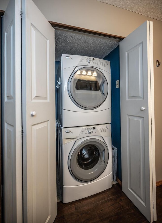 washroom featuring stacked washer / dryer, a textured ceiling, laundry area, and dark wood finished floors