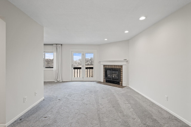 unfurnished living room with recessed lighting, carpet flooring, a brick fireplace, and baseboards