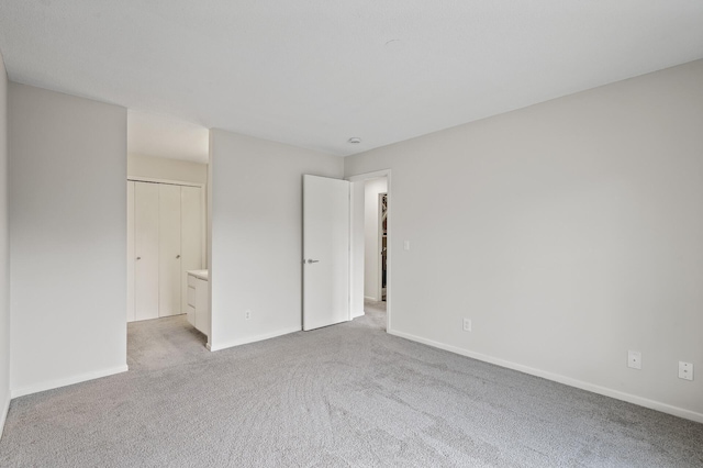 unfurnished bedroom with light carpet and baseboards