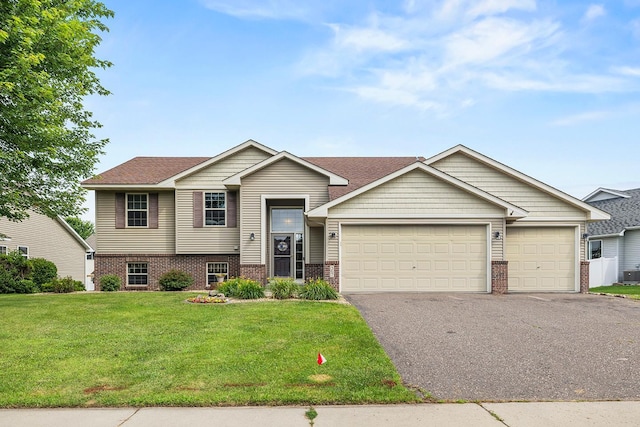367 Garden Dr, Delano, MN 55328 - view of front facade with brick siding, driveway, an attached garage, a front lawn, and roof with shingles