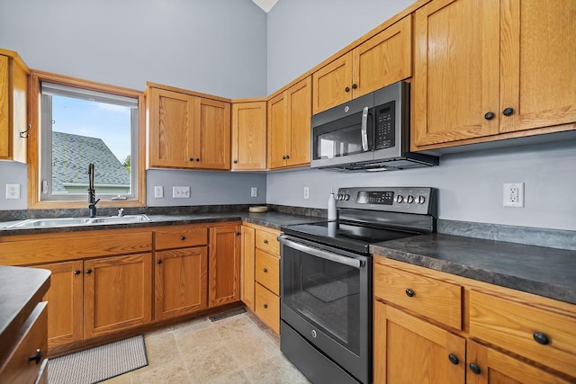 367 Garden Dr, Delano, MN 55328 - kitchen featuring black electric range, dark countertops, and brown cabinetry