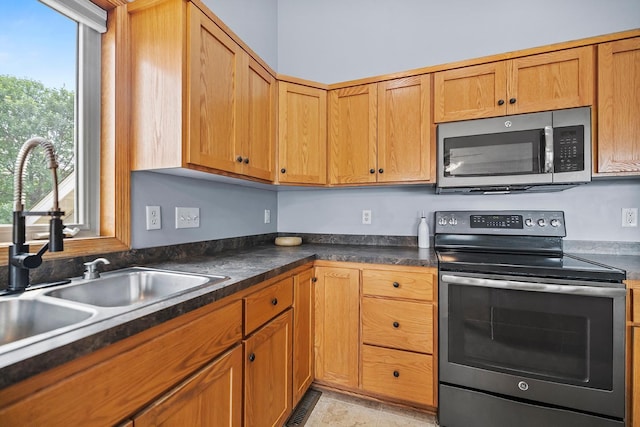 367 Garden Dr, Delano, MN 55328 - kitchen with electric stove, stainless steel microwave, dark countertops, and brown cabinets