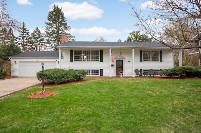bi-level home with concrete driveway, a chimney, a front lawn, and an attached garage