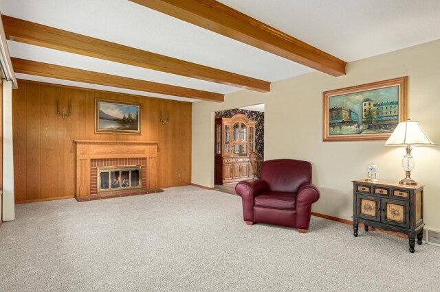 sitting room with baseboards, beamed ceiling, and carpet