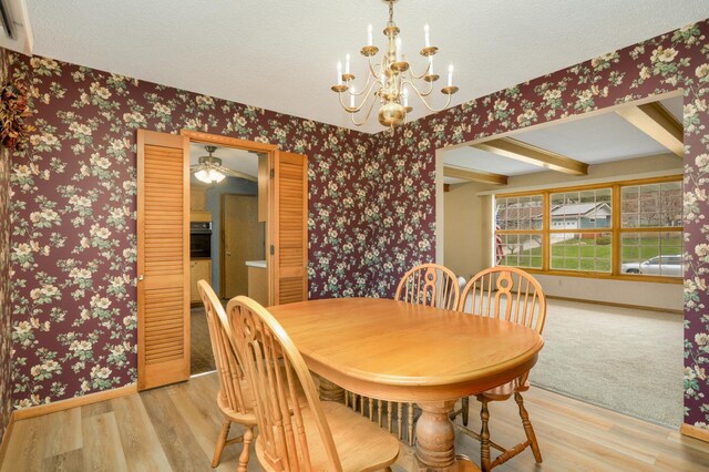 dining room with baseboards, an inviting chandelier, wallpapered walls, and wood finished floors