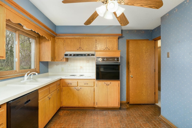kitchen with a sink, black appliances, light countertops, brick patterned floor, and wallpapered walls