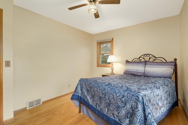 bedroom featuring visible vents, wood finished floors, baseboards, and ceiling fan